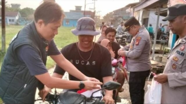 Personel Polsek Makarti Jaya bagikan Bendera Merah Putih kepada pengendara di Banyuasin sambut HUT ke-81 RI.