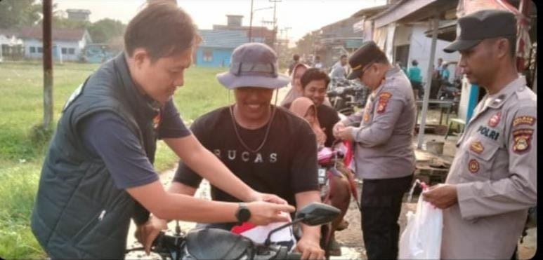 Personel Polsek Makarti Jaya bagikan Bendera Merah Putih kepada pengendara di Banyuasin sambut HUT ke-81 RI.