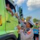 Anggota Polantas Banyuasin membagikan makanan gratis kepada pengendara di tengah kemacetan Jalintim Palembang-Betung.